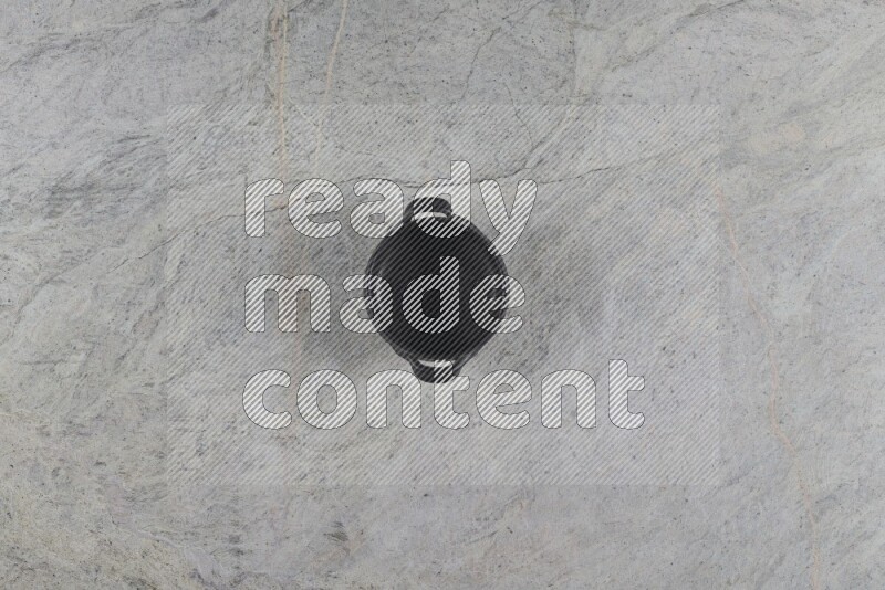 A black pottery bowl on grey marble background