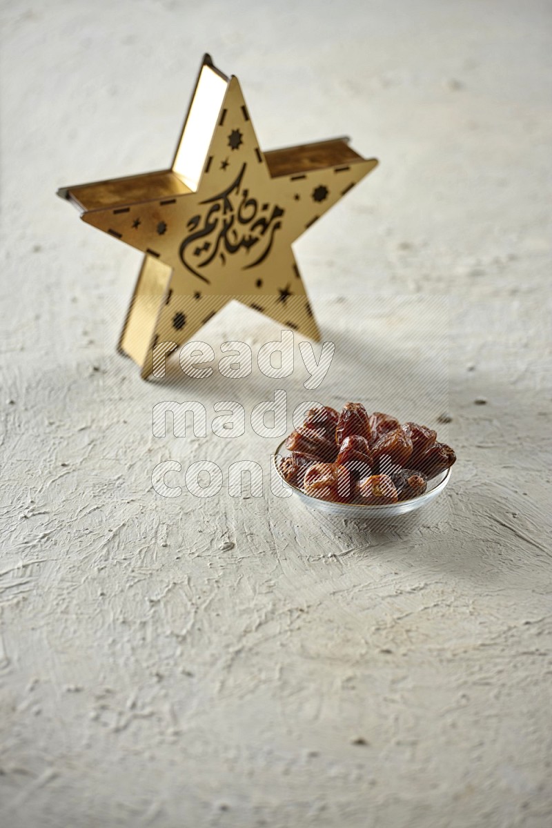 A wooden golden star lantern with different drinks, dates, nuts, prayer beads and quran on textured white background