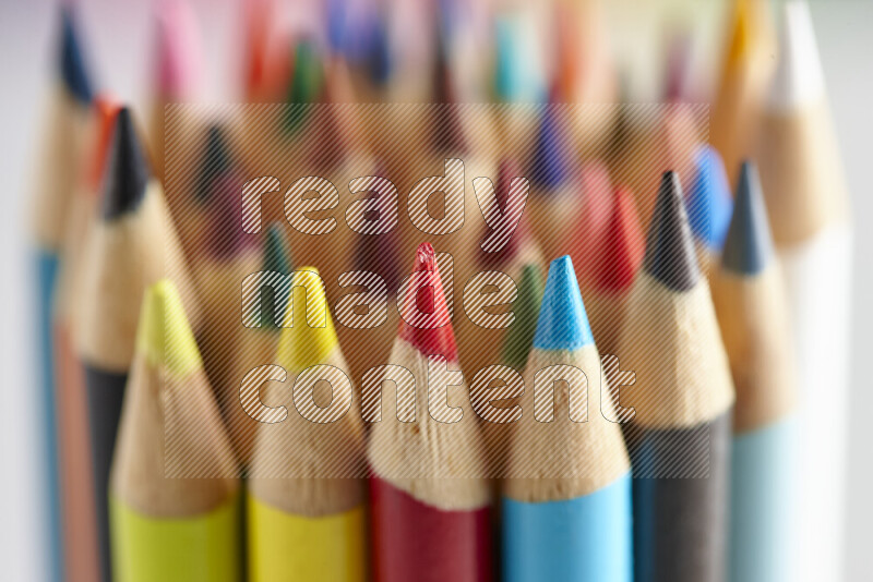 The image captures a close-up of sharpened colored pencils on multicolored background