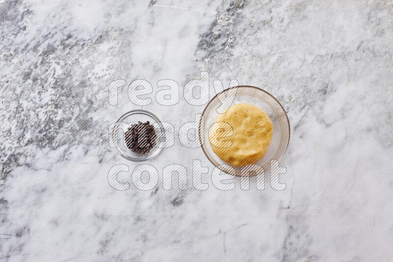 Cookies step by step with its ingredient, flour, butter, brown sugar, egg, vanilla extract, white sugar, chocolate chips and baking soda on grey marble background
