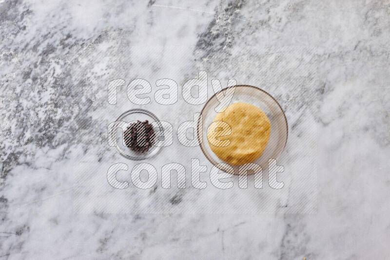 Cookies step by step with its ingredient, flour, butter, brown sugar, egg, vanilla extract, white sugar, chocolate chips and baking soda on grey marble background