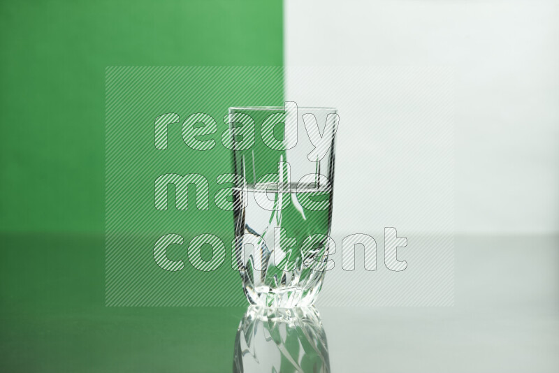 The image features a clear glassware filled with water, set against white and green background