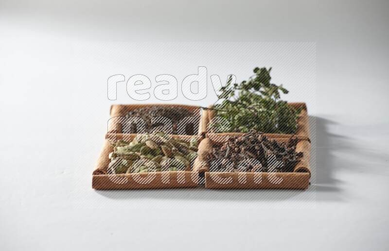 4 squares of cinnamon sticks full of tea, cardamom, mint and cloves on white flooring