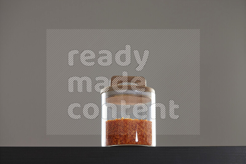 Lentils in a glass jar on black background