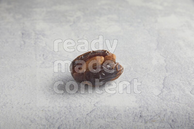 almond stuffed madjoul date on a light grey background