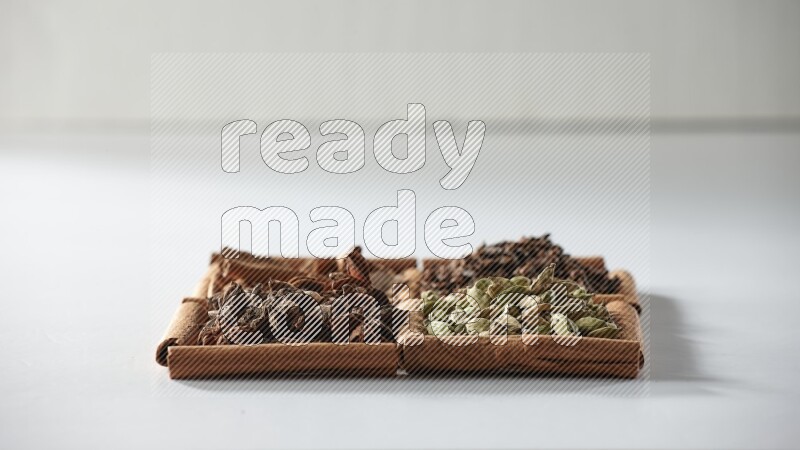 4 squares of cinnamon sticks full of cardamom, star anise, cloves and cinnamon on white flooring