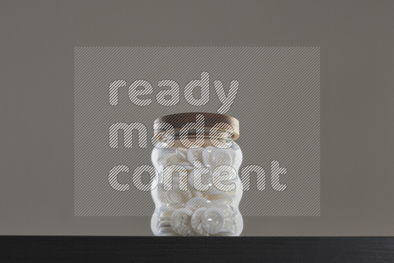 Buttons in a glass jar on black background