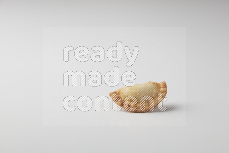 One fried sambosa on a white background