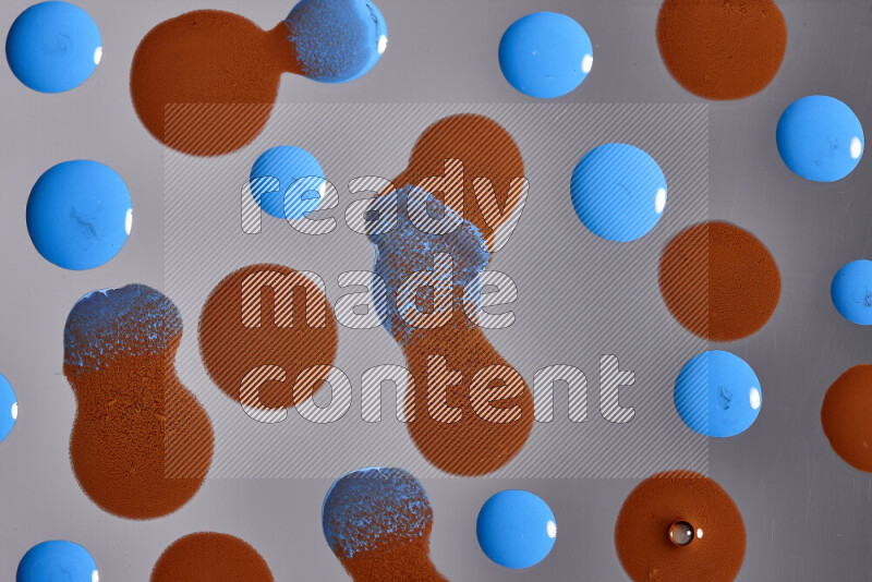 Close-ups of abstract orange and blue paint droplets on the surface