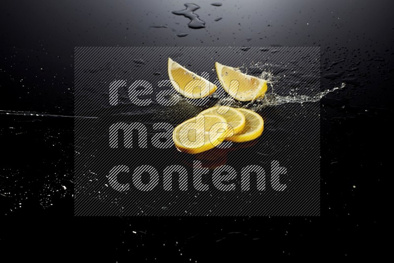 Lemon slices with water drops, and droplets on black background