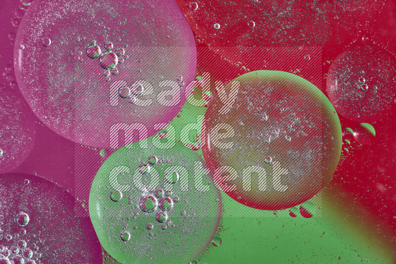 لقطات مقربة لفقاعات من الزيت على سطح الماء باللون الوردي والأخضر والأحمر
