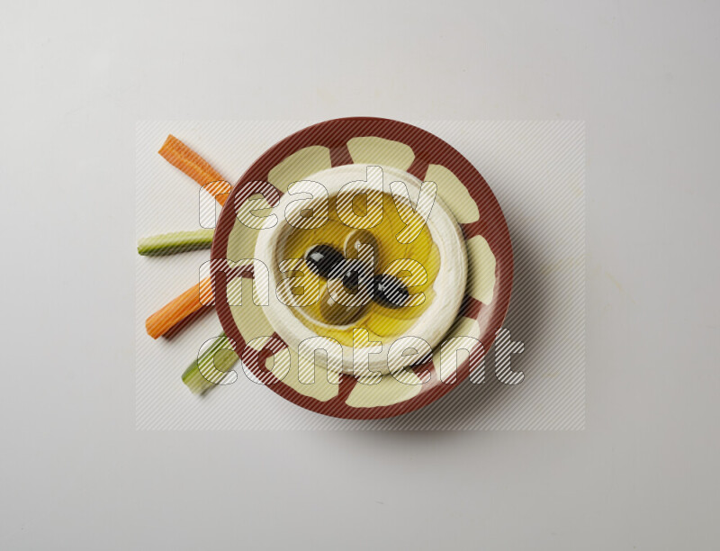 Lebnah garnished with olives in a traditional plate on a white background