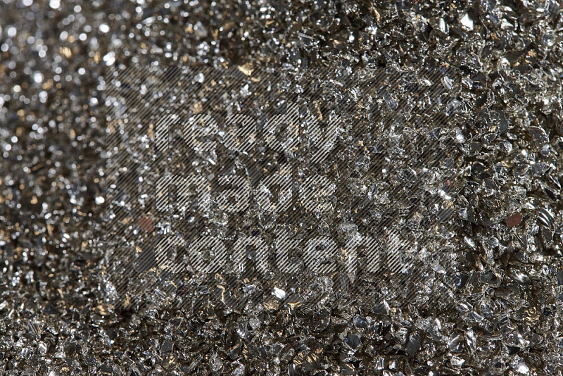 Silver shimmering fragments of glass scattered on a black background