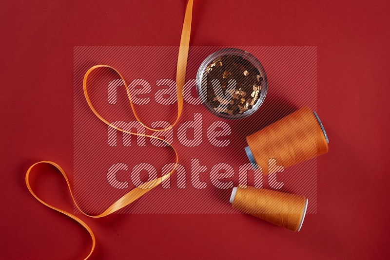 Orange sewing supplies on red background