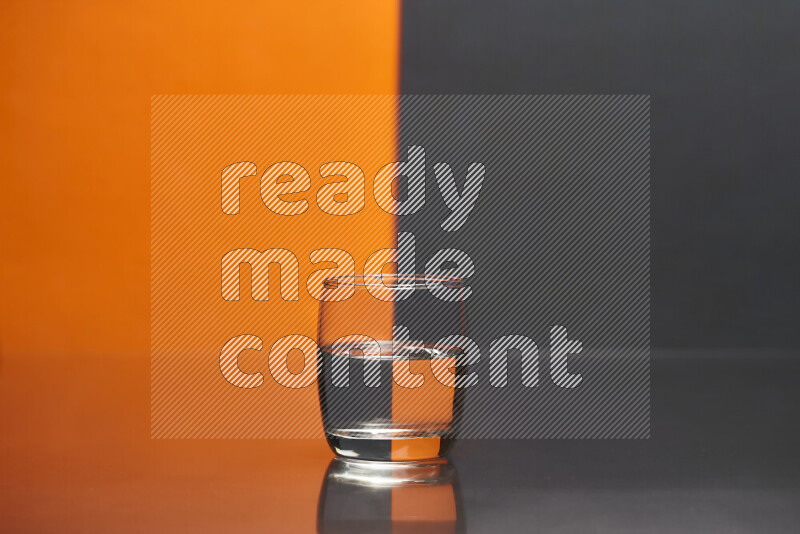 The image features a clear glassware filled with water, set against orange and black background