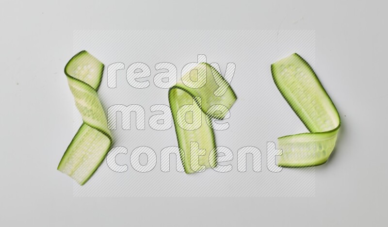 Three cucumber ribbons on a white background
