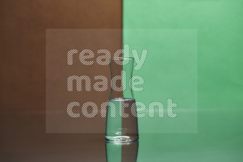 تظهر الصورة أواني زجاجية ممتلئة بالماء موضوعة على خلفية من اللونين البني والأخضر