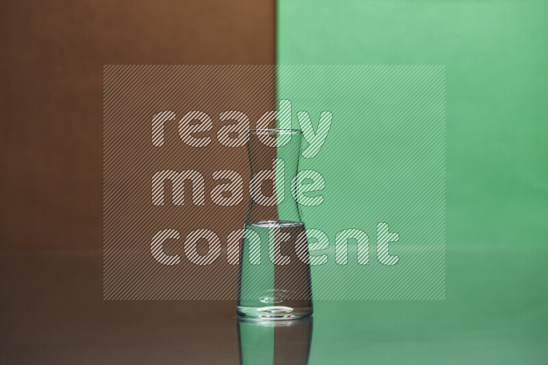 The image features a clear glassware filled with water, set against brown and green background