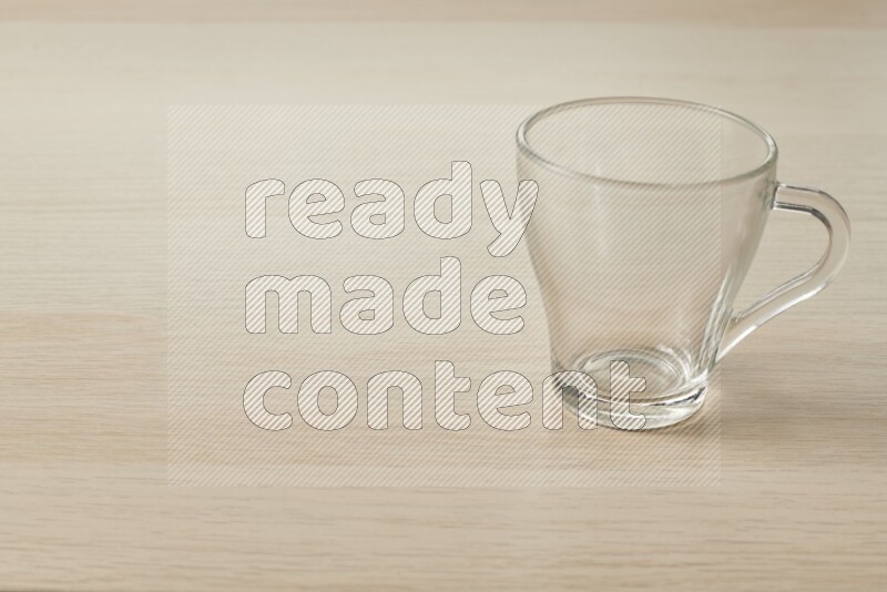 An empty glass cup on light wooden background