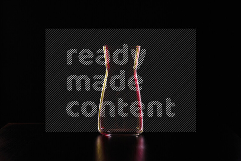 Glassware with rim light in red and yellow against black background