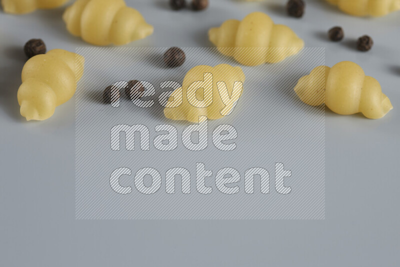 معكرونة مع مكونات متنوعة من الطماطم والثوم والبصل والفلفل الأحمر والفلفل الأسود والفلفل الأبيض وأوراق الغار وإكليل الجبل والهيل و مشروم على خلفية زرقاء فاتحة