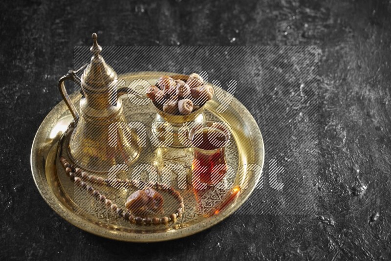 Dates with a drink on a metal tray in a dark setup