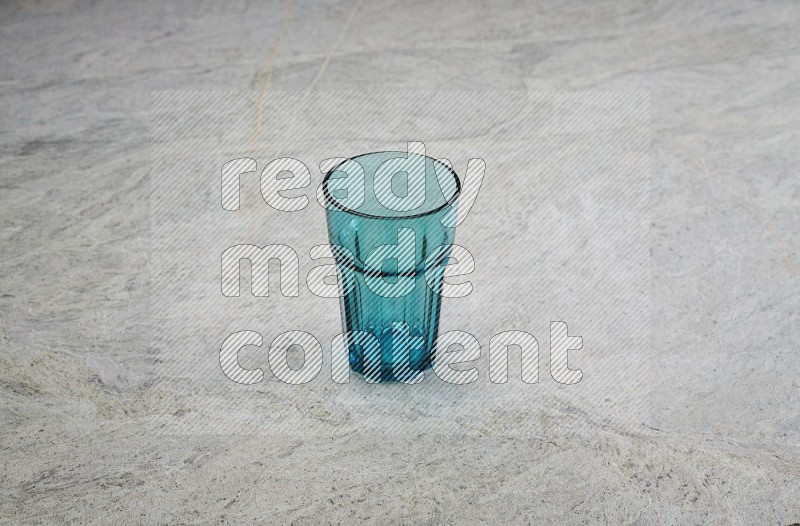 A Turquoise Glass On Grey Marble Flooring