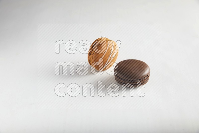 45º Shot of of two assorted Brown Irish Cream, and Brown Dark Chocolate macarons on white background