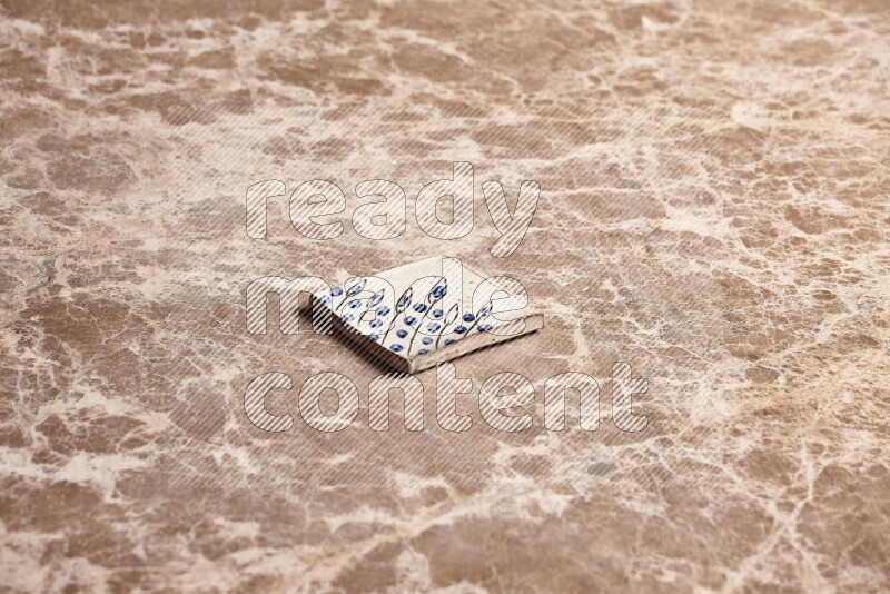 A decorative coaster on beige marble background