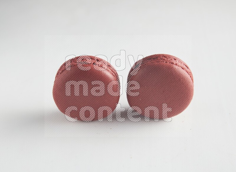 45º Shot of two Red Velvet macarons on white background