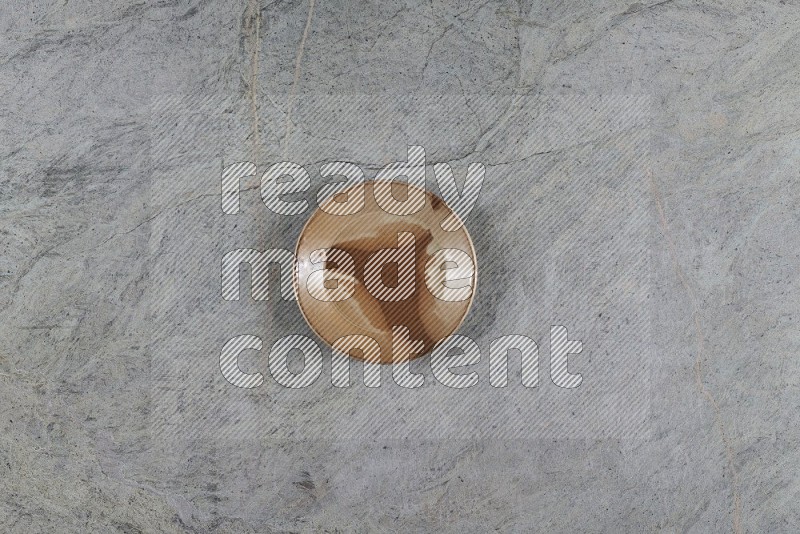 Top View Shot Of A Multicolored Pottery Plate On Grey Marble Flooring