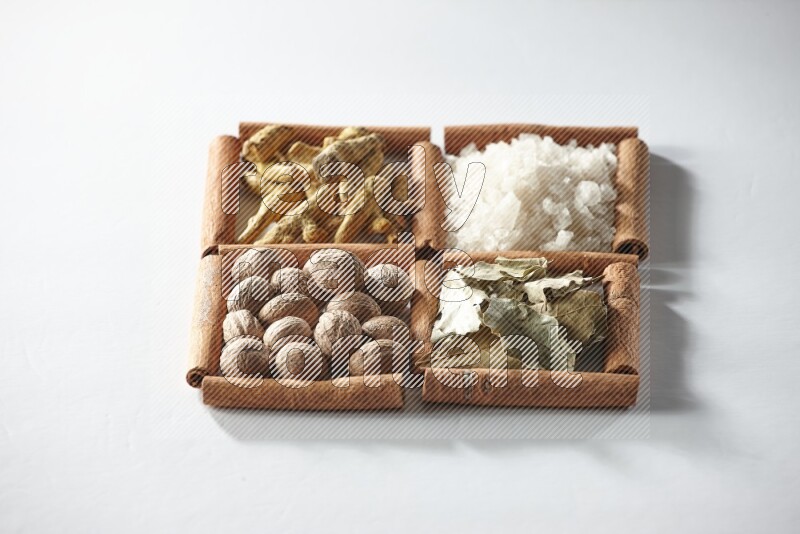 4 squares of cinnamon sticks full of salt, bay laurel, nutmeg, turmeric on white flooring