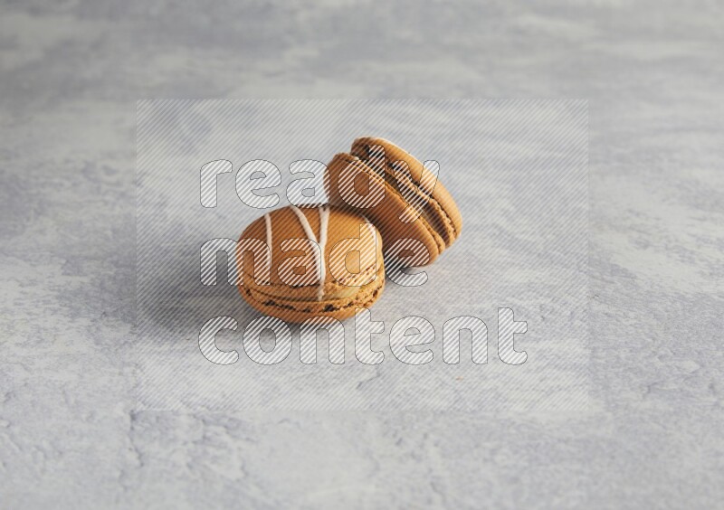 45º Shot of two Brown Irish Cream macarons  on white  marble background