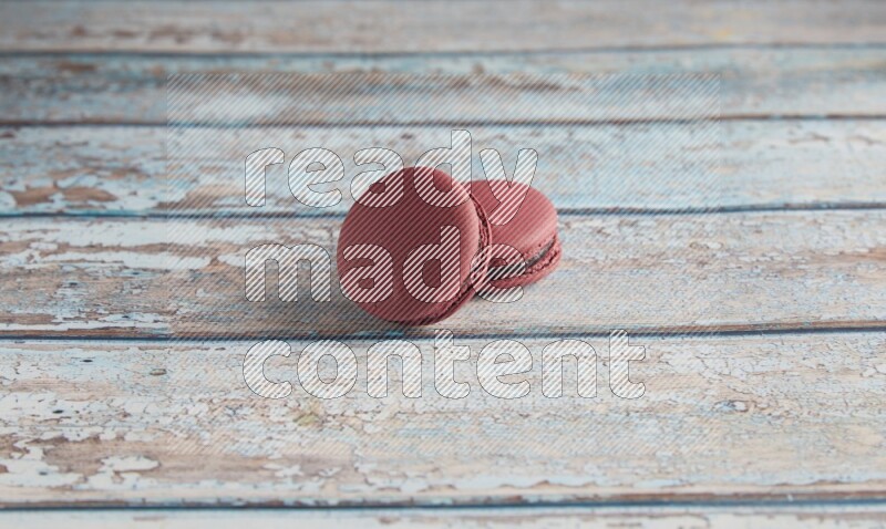 45º Shot of two Red Cherry macarons on light blue wooden background