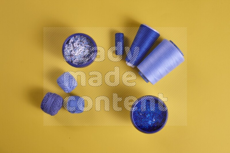 A blue collection of sewing and tailoring tools arranged on a yellow background