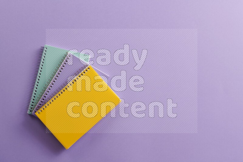 Multicolored notebooks on purple background