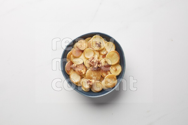 Top-view shot of walnut cereal pancakes in a round bowl on white background