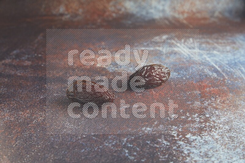 two madjoul dates on a rustic reddish background