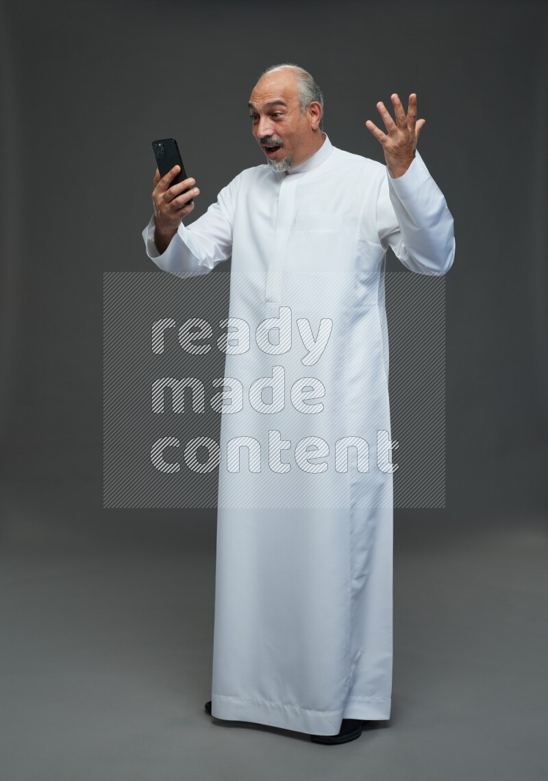 Saudi man without shomag Standing taking selfie on gray background