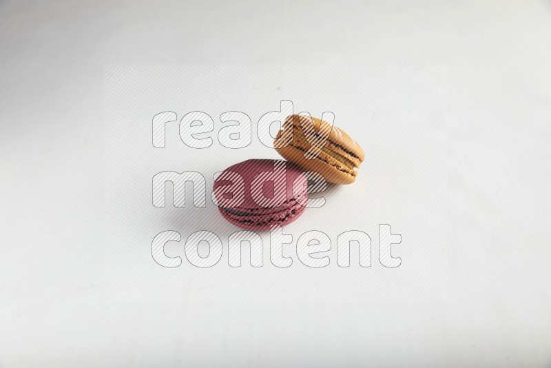 45º Shot of of two assorted Brown Irish Cream, and Red Cherry macarons on white background