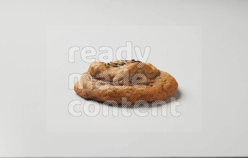 Hasawi cookie field with date and decorated by black seed and Anise grain on a white background
