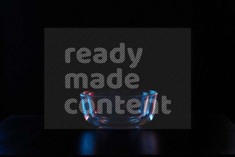 Glassware with rim light in red and blue against black background