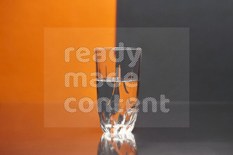 The image features a clear glassware filled with water, set against orange and black background