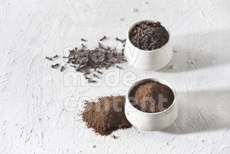 وعاءين من السيراميك بيج اللون، أحدهما مملوء بالقرنفل والآخر مملوء بالبودرة على أرضية بيضاء