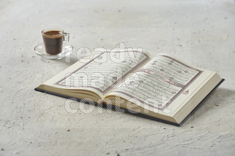 Quran with dates, prayer beads and different drinks all placed on textured white background
