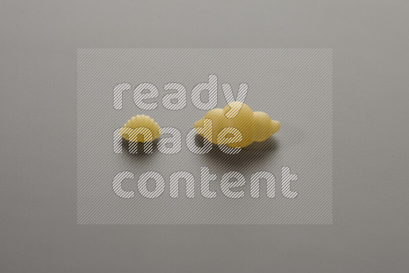 معكرونة ودعة في وعاء فخاري علي خلفية رمادية