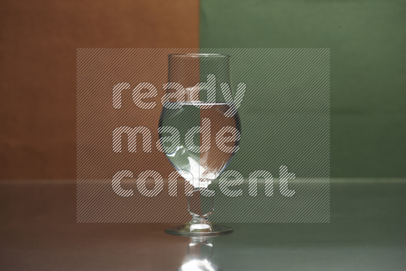 The image features a clear glassware filled with water, set against brown and dark green background