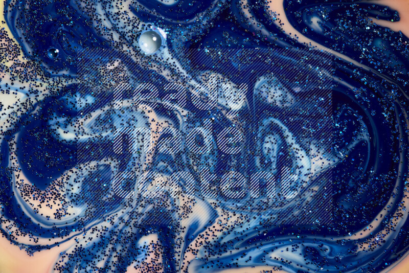 A close-up of sparkling blue glitter scattered on swirling blue and orange background