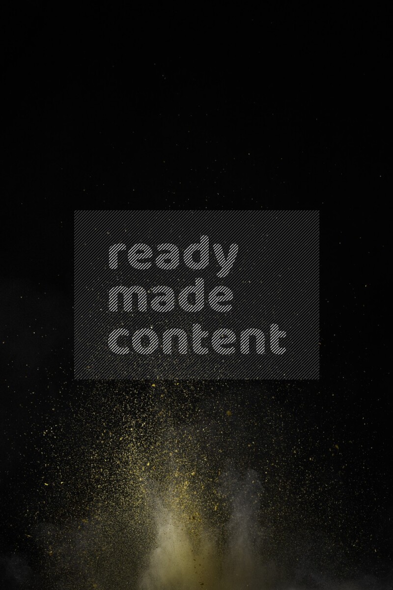 A side view of yellow powder explosion on black background