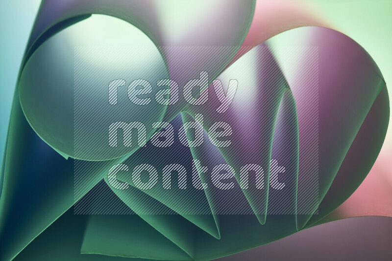 عرض فني لطيات الورق تخلق مزيج من الأشكال الهندسية، مضاءة بإضاءة ناعمة بدرجات اللون الأخضر والوردي